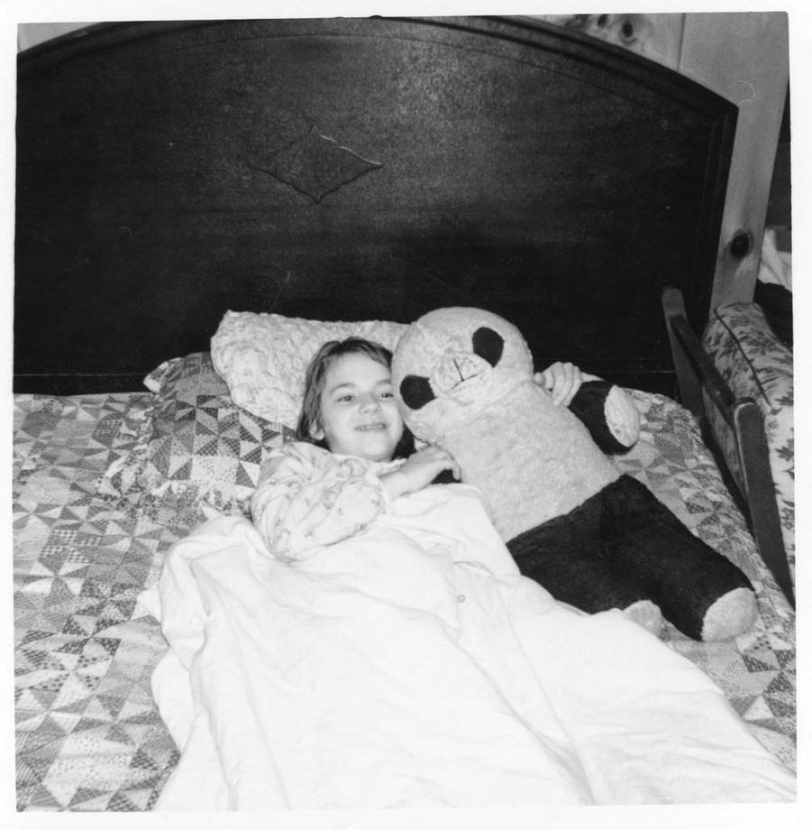 Rachael as a small child holding a toy panda